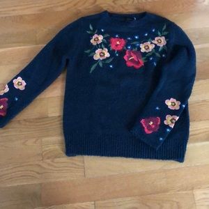 Navy blue sweater with stitched flowers.